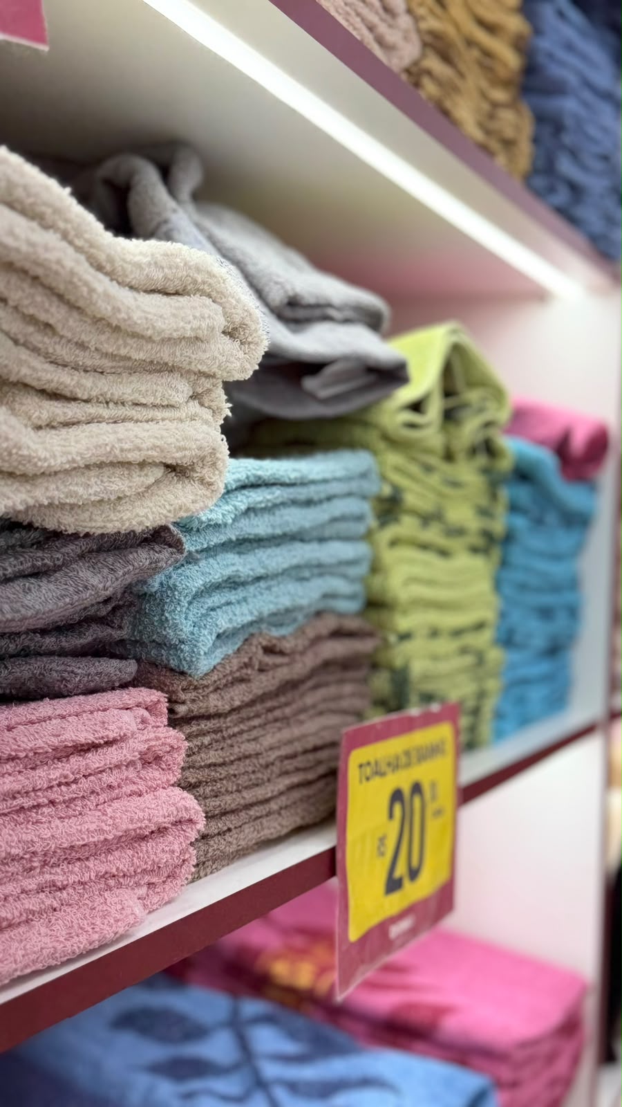 Toalhas coloridas empilhadas na seção de cama, mesa e banho